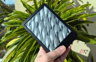 Amazon Kindle 2024 in hand in front of leafy plant