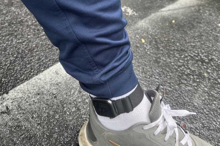 An Apple Watch on an ankle outside on pavement