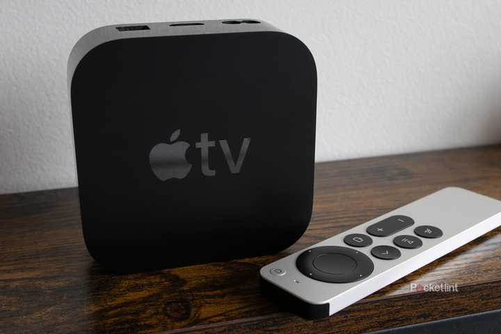 The Apple TV 4K sitting on a shelf with the Siri Remote 
