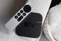 The Apple TV 4K and the Siri Remote sitting on a couch arm
