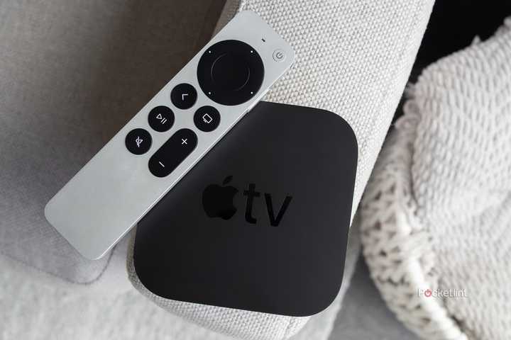 The Apple TV 4K and the Siri Remote sitting on a couch arm