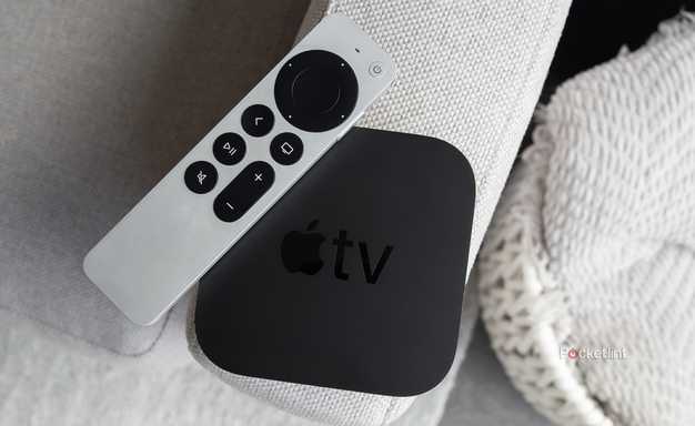The Apple TV 4K and the Siri Remote sitting on a couch arm