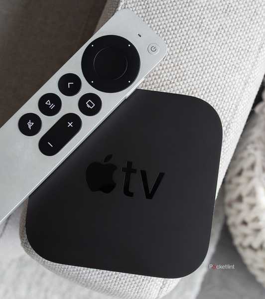 The Apple TV 4K and the Siri Remote sitting on a couch arm