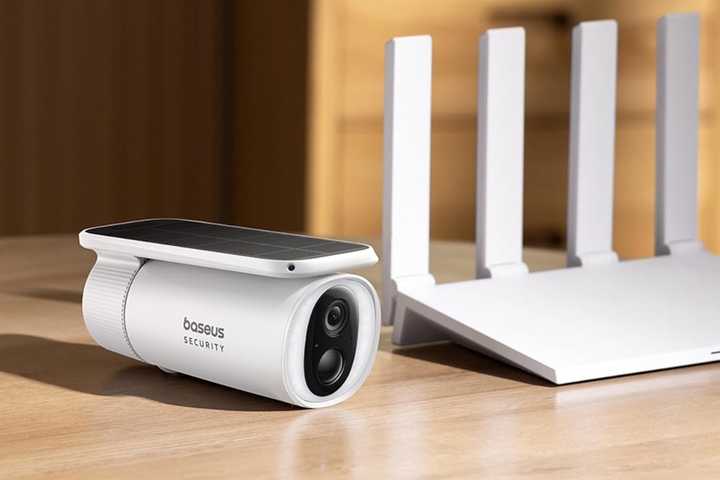 baseus outdoor security camera on desk next to router