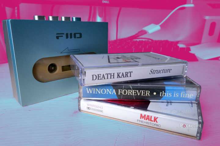 A stack of cassette tapes in front of a cassette player