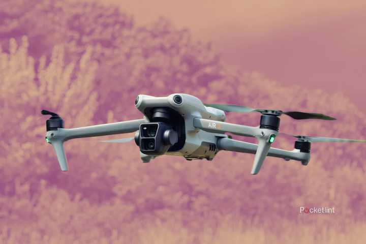 A DJI drone in front of a light orange background.