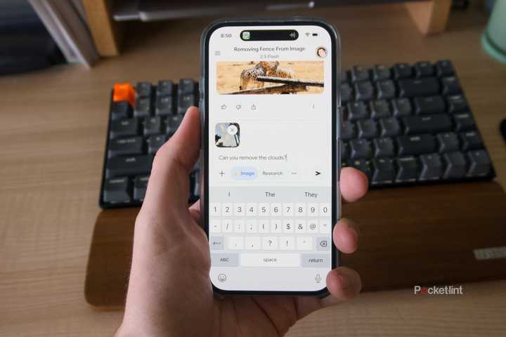A hand holding an iPhone 16 displaying the Gemini app editing a photo.