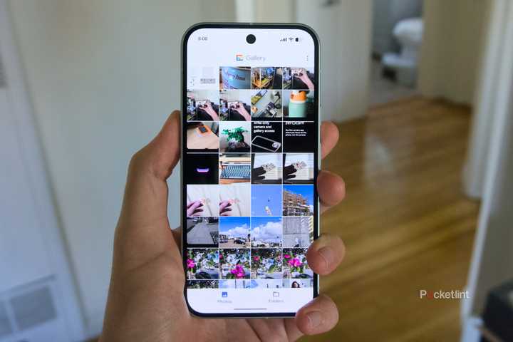 A hand holding a Pixel 9 displaying the library of the Google Gallery app.
