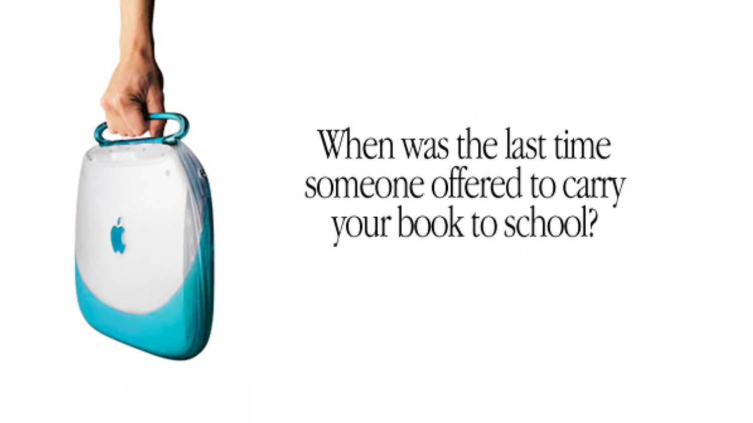 A hand holding a blue iBook in an Apple ad.