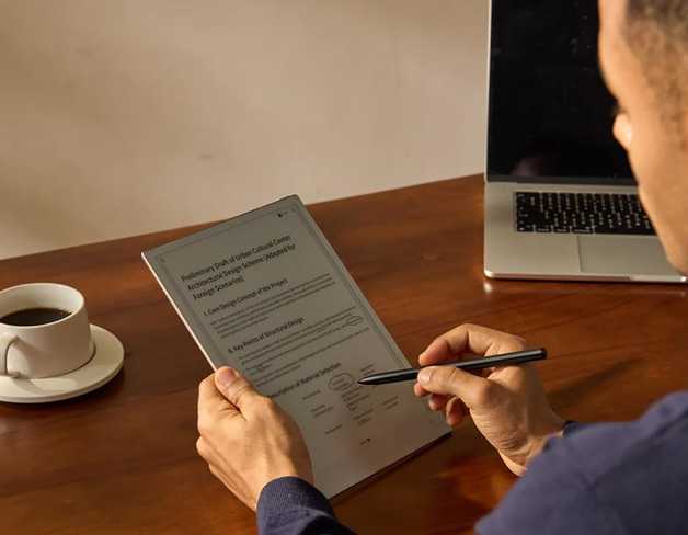 The iFlyTek AINOTE 2 E-ink tablet and smartpen in someone's hands.