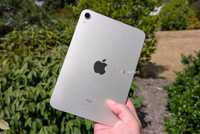 An iPad mini being held up in the air.