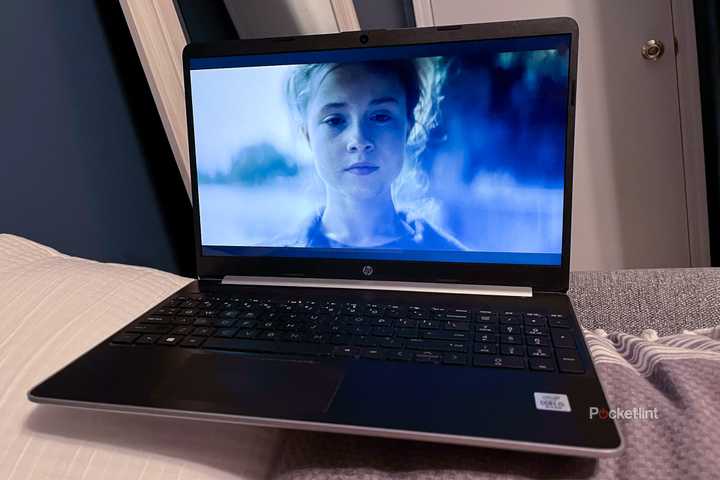 An older laptop sitting on a bed 