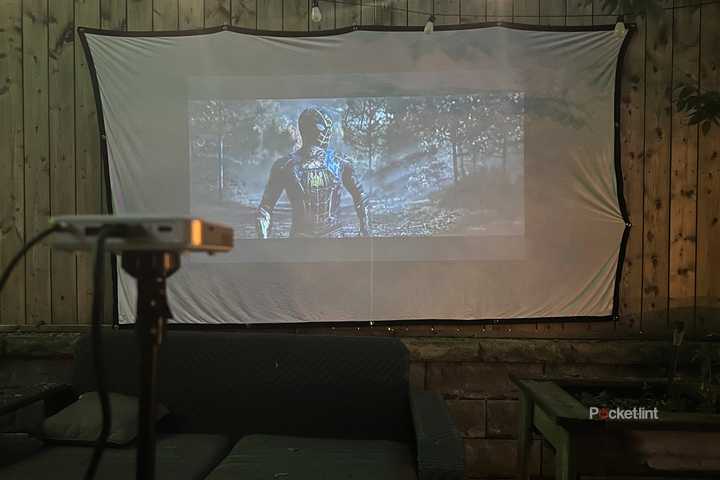 Spiderman being thrown on an outdoor movie projector. 
