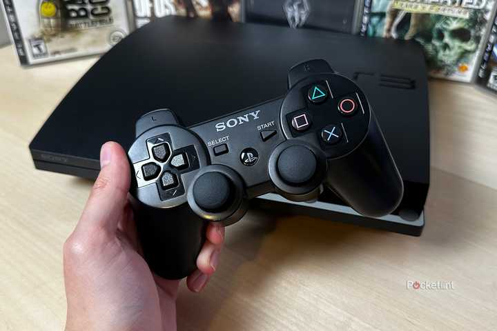 PS3 controller in front of PS3 console and games.