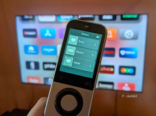 A Sofabaton X2 remote in front of a TV.