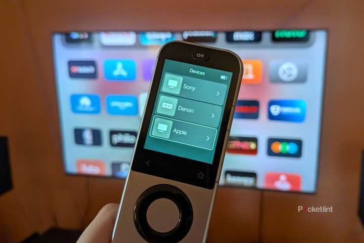 A Sofabaton X2 remote in front of a TV.