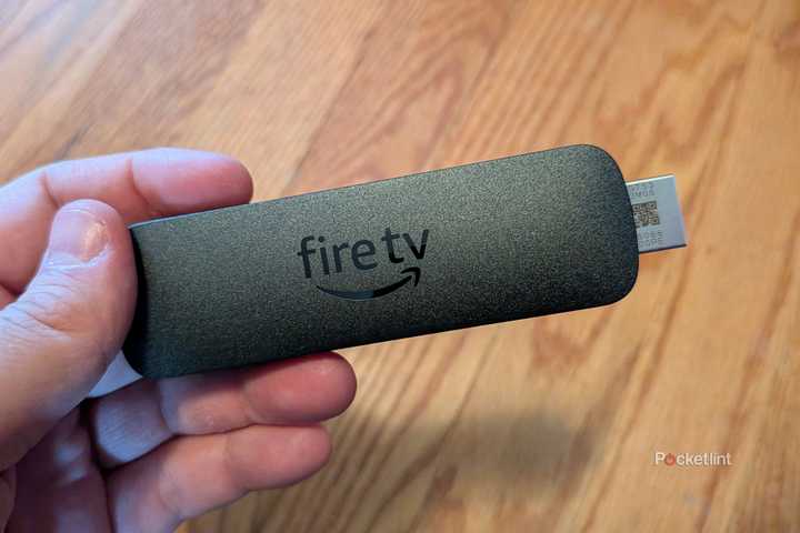 A person holding the Amazon Fire TV Stick 4K Select.