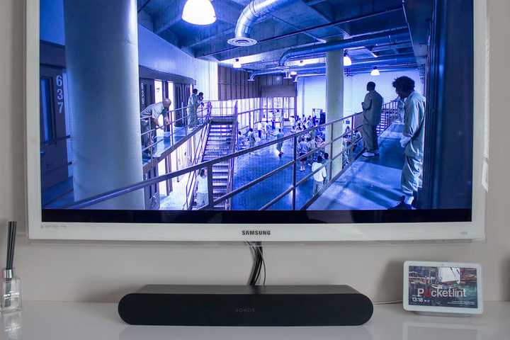 A black Sonos Ray sound bar under a white television.