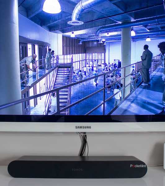 A black Sonos Ray sound bar under a white television.