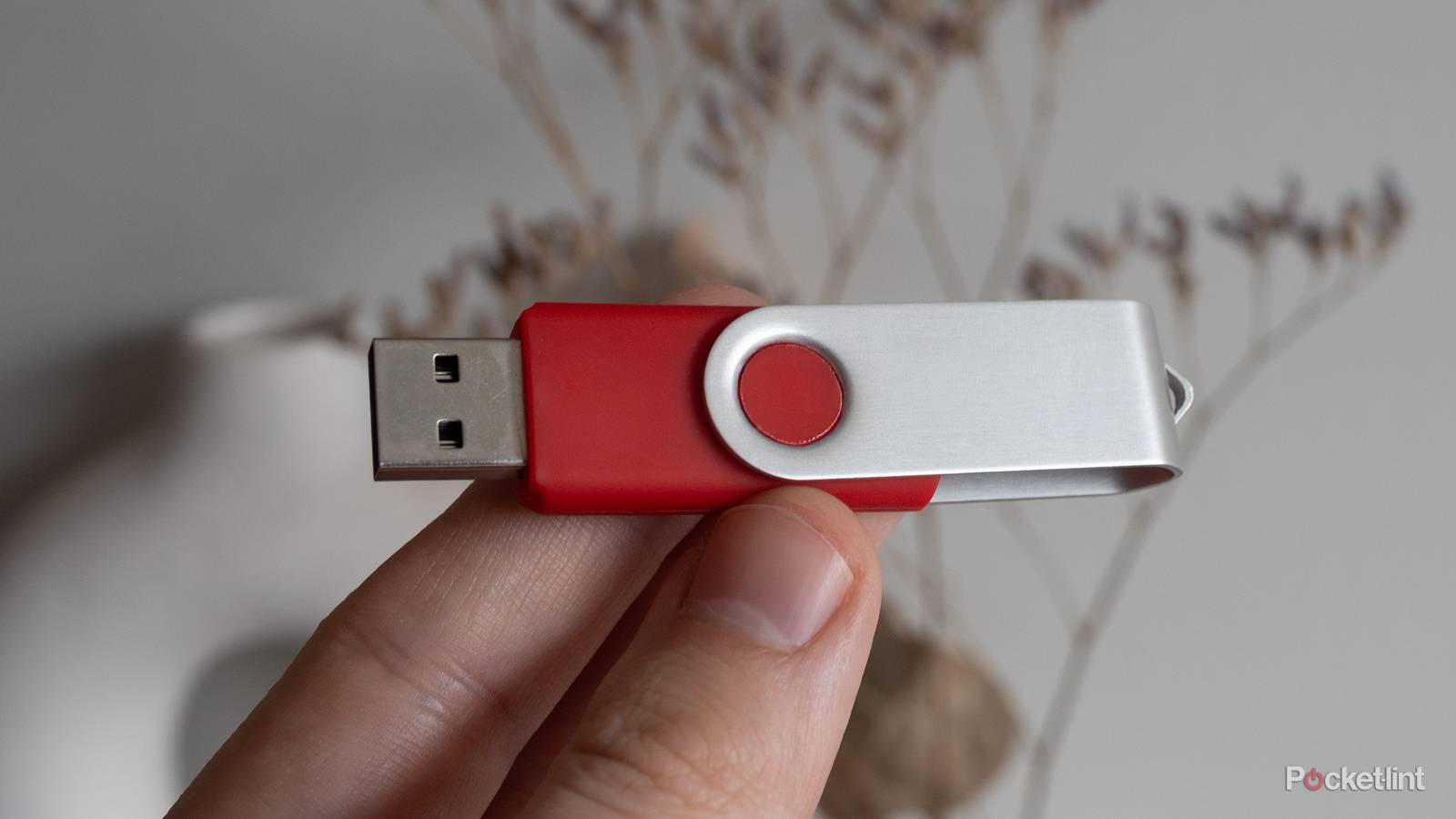 Holding a red USB stick 