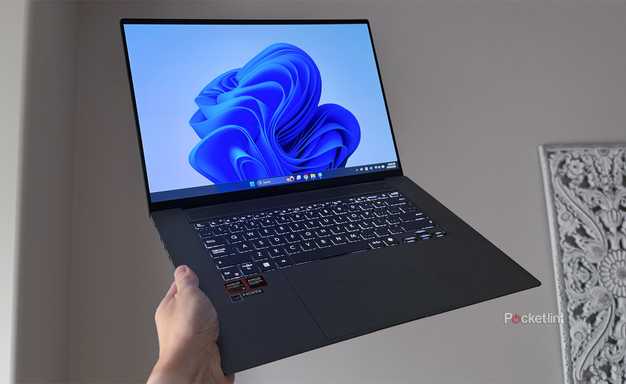 A Windows 11 laptop being held up in the air.