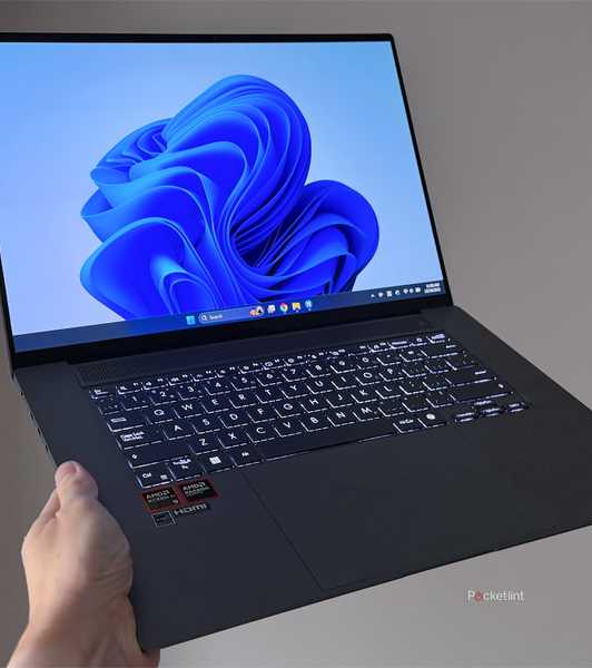 Windows 11 laptop being held up in the air.